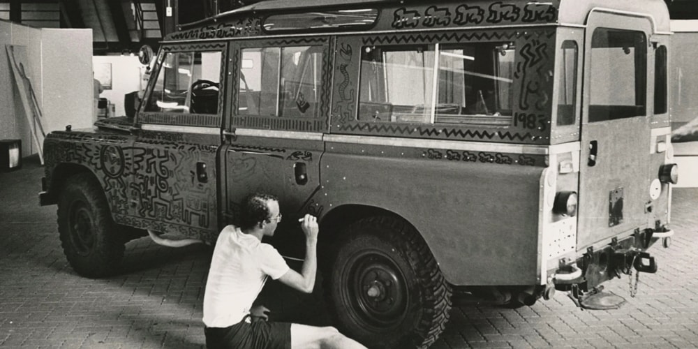 Artiste peignant un véhicule vintage avec des motifs abstraits.