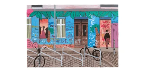 Bâtiment coloré avec graffitis, vélos attachés devant.