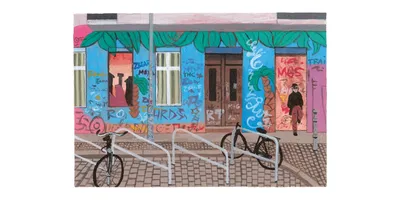 Bâtiment coloré avec graffitis, vélos attachés devant.