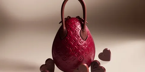 Sac ovale rouge avec motifs et chocolats en forme de cœur autour.
