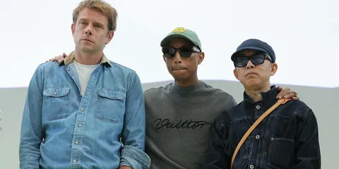 Trois hommes posant ensemble, habillés décontractés.