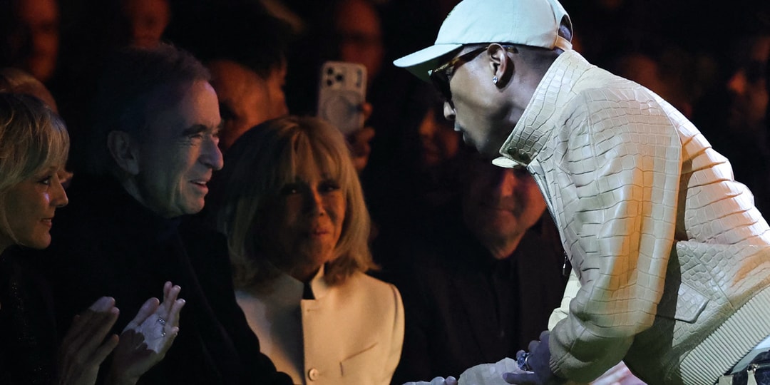 Personne saluant individuellement, public attentif en arrière-plan.