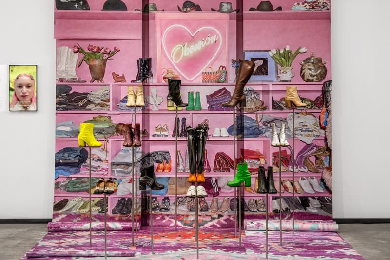 Murs roses avec chaussures à talons et enseigne néon 'Obsession'.