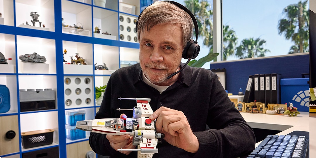 Homme avec casque construit un modèle de vaisseau spatial en briques.
