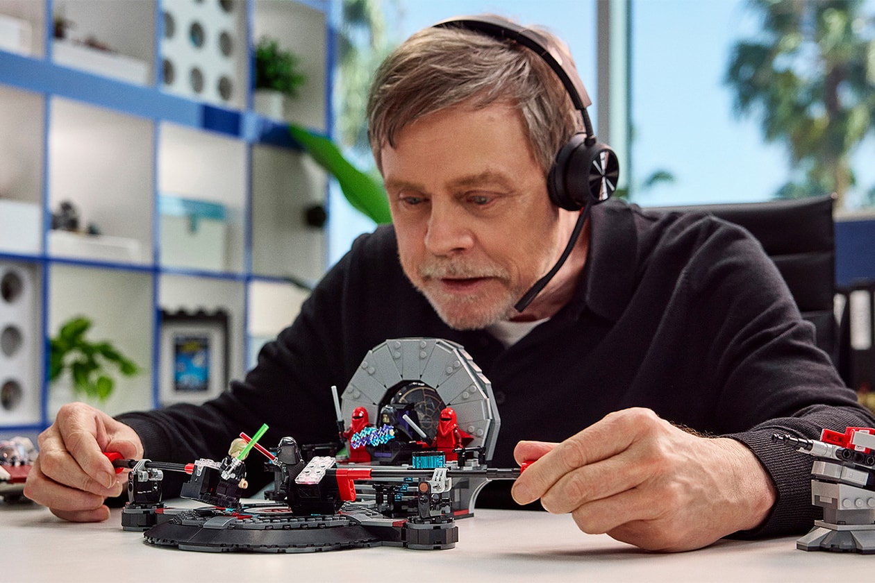 Homme jouant avec ensemble LEGO sur une table, portant un casque.
