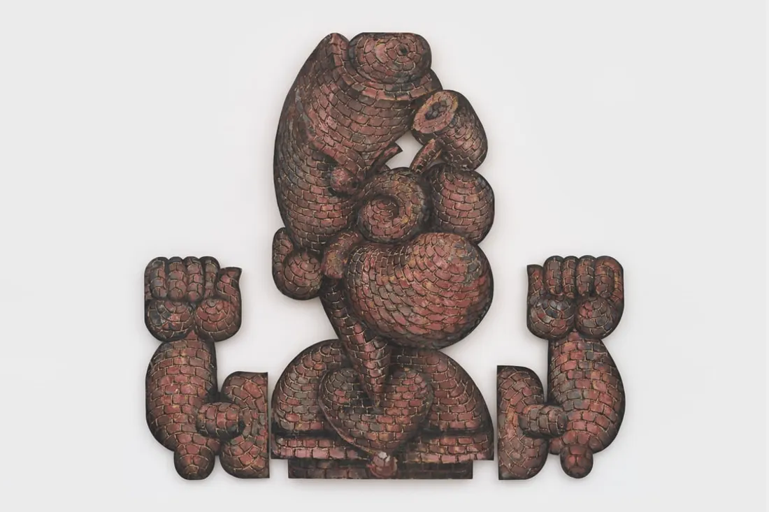 Sculpture de personnage stylé avec muscles proéminents et texture de briques.