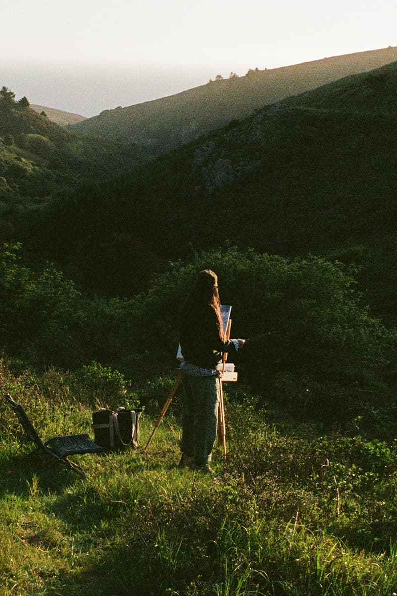Personne peignant dans un paysage de montagne ensoleillé.