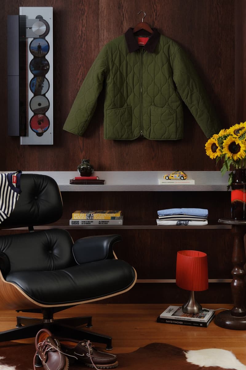 Intérieur avec veste verte suspendue et tournesols sur une table.