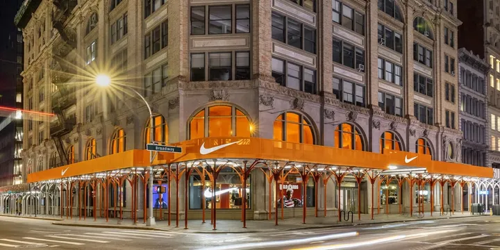 Bâtiment avec échafaudages orange et enseigne Nike lumineux à New York.