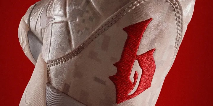 Basket blanche avec logo rouge sur fond rouge.