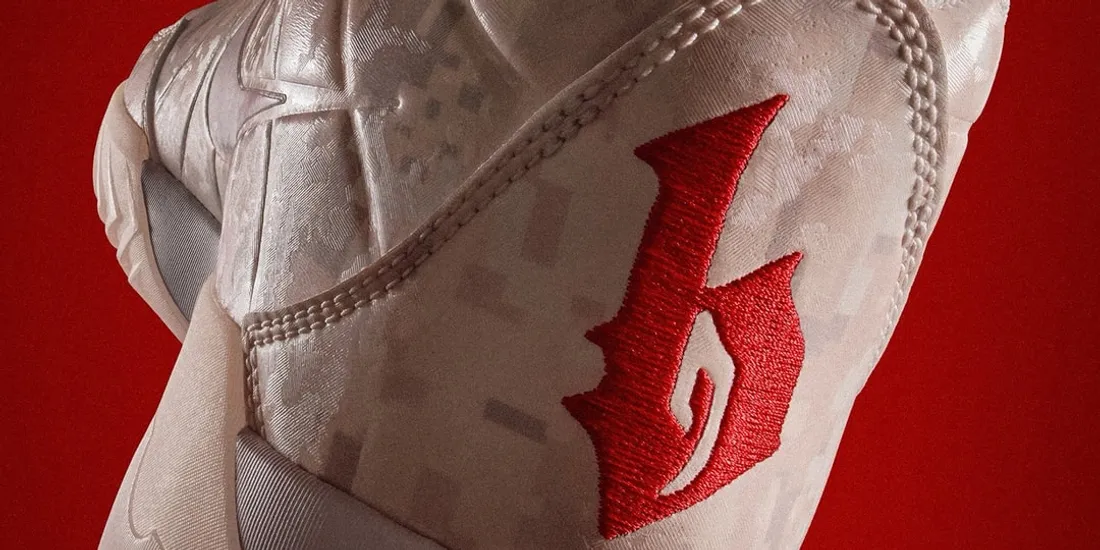 Basket blanche avec logo rouge sur fond rouge.