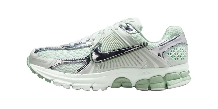 Chaussure de sport blanc et vert avec accents argentés, logo Nike visible.