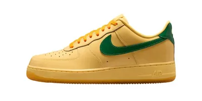 Chaussure Nike jaune avec logo vert et semelle marron.