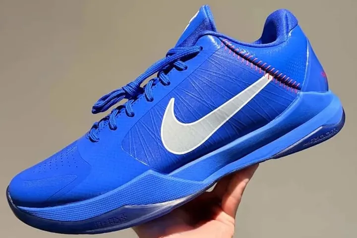 Chaussure de sport bleue avec logo Nike blanc.