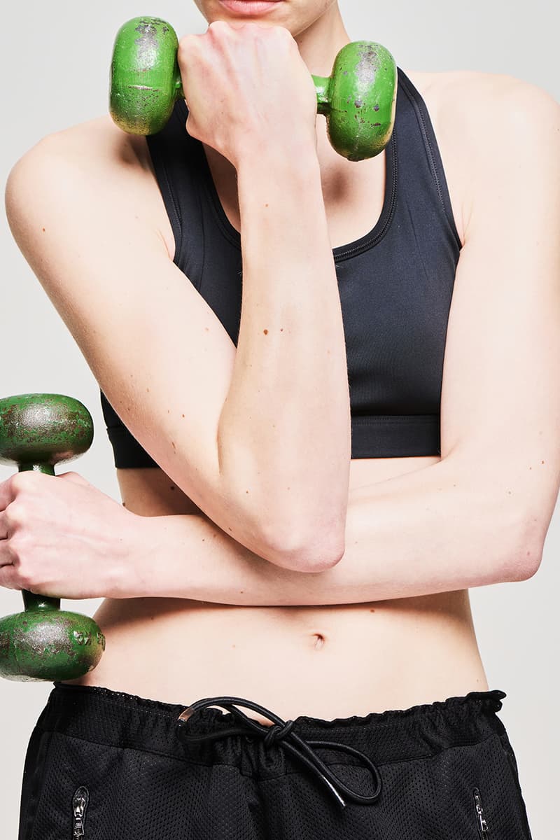 Femme en tenue de sport tenant des haltères verts.