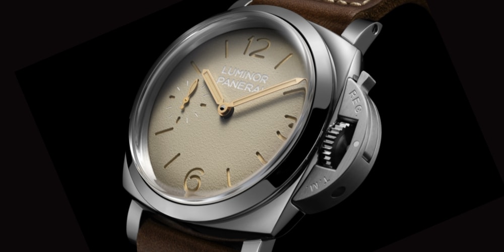 Montre avec cadran beige et bracelet en cuir marron.