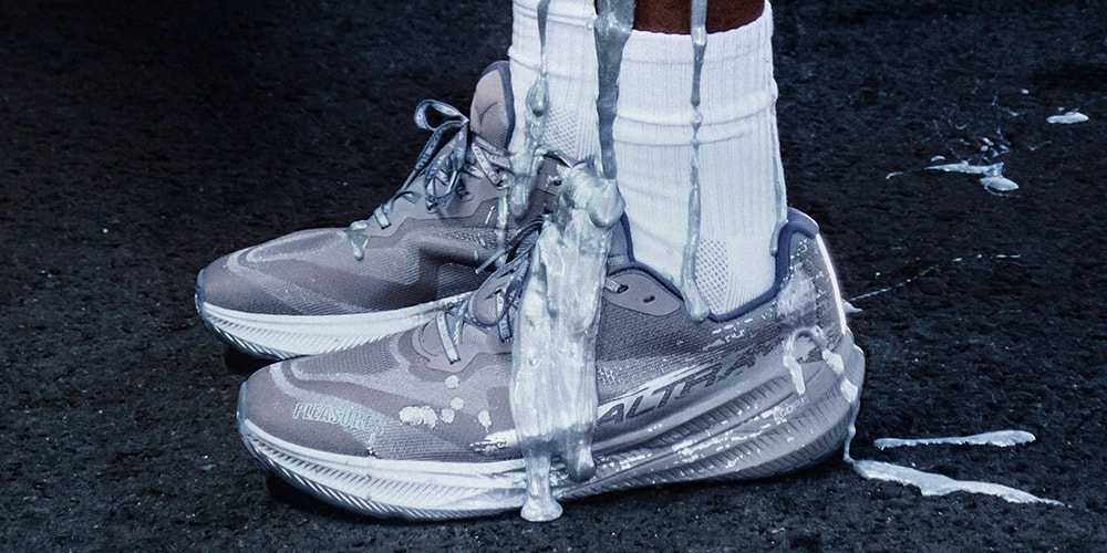 Chaussures de sport grises éclaboussées de liquide blanc sur le sol.