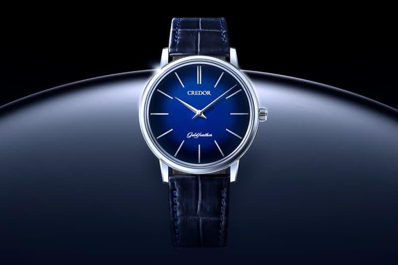 Montre bleue élégante avec bracelet en cuir, fond noir.
