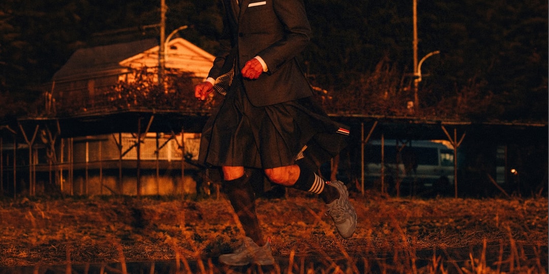 Personne en costume courant dans un paysage au crépuscule.