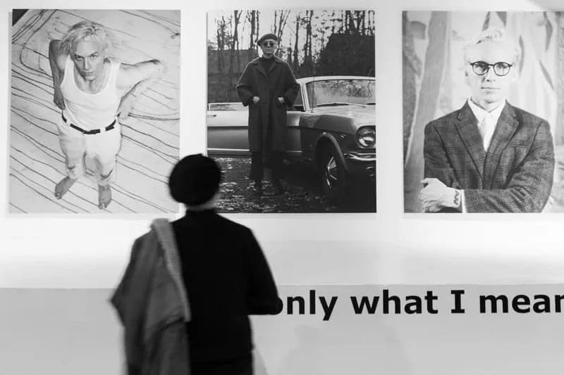 Personne regardant des photos de mode en noir et blanc sur un mur.