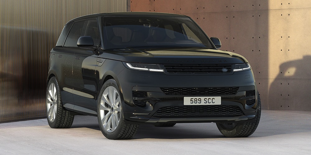 SUV noir moderne devant mur béton et verre