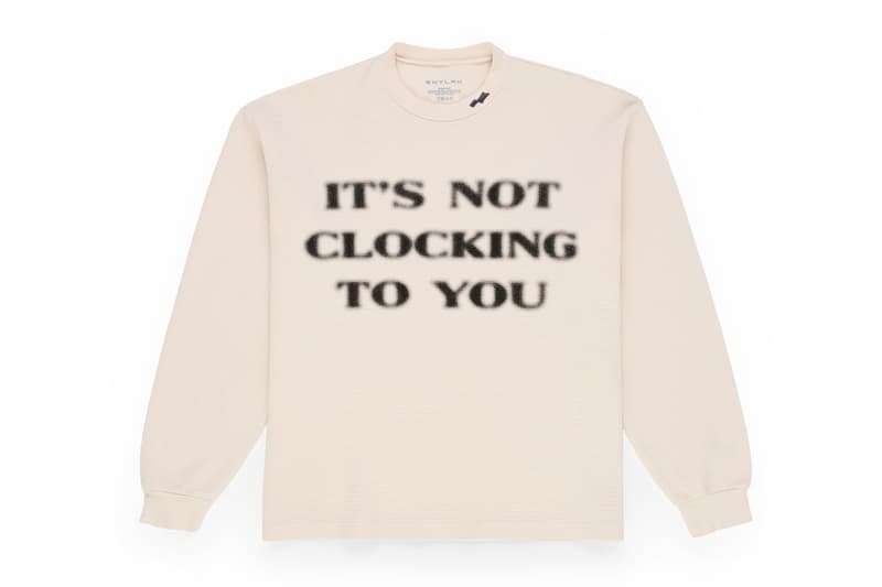 Sweatshirt beige avec texte 'IT'S NOT CLOCKING TO YOU'.