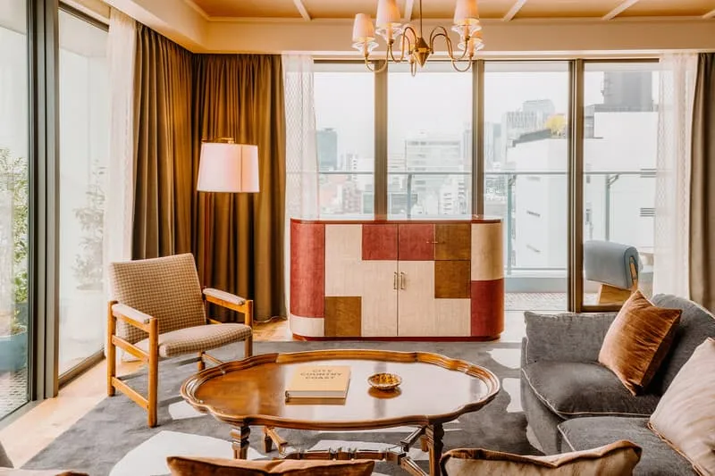 Salon élégant avec meubles modernes et vue sur la ville, éclairage chaleureux.