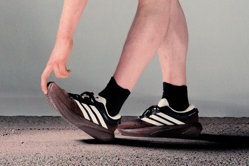 Une personne avec des bras et jambes chaussés de baskets noires à rayures blanches.