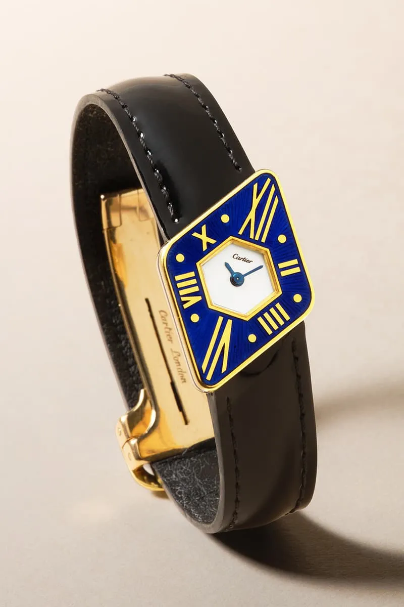 Montre Cartier avec cadran bleu et chiffres romains jaunes, bracelet en cuir noir.