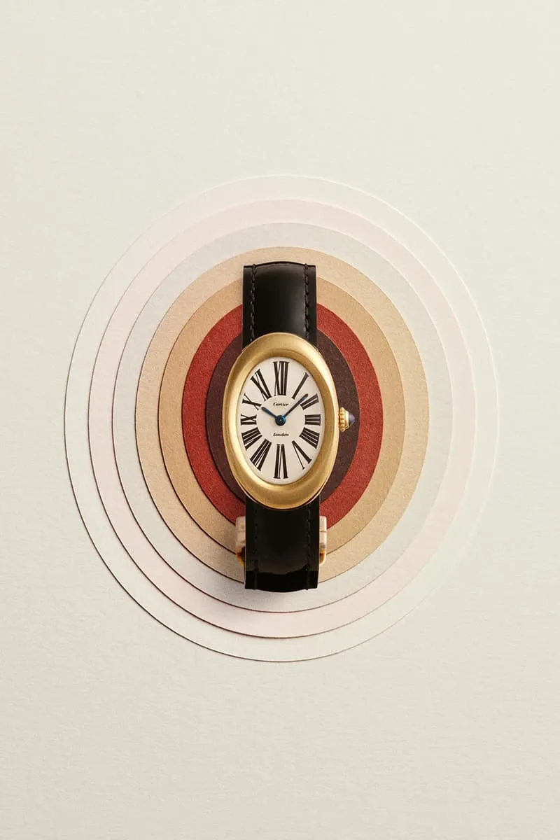 Montre avec bracelet noir sur fond de cercles concentriques colorés.