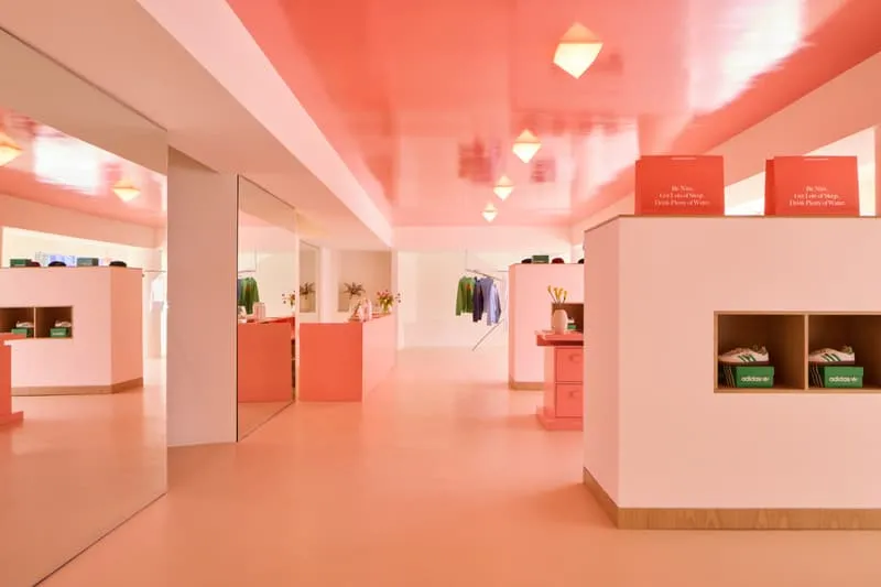Magasin moderne avec intérieur rose et vêtements exposés.