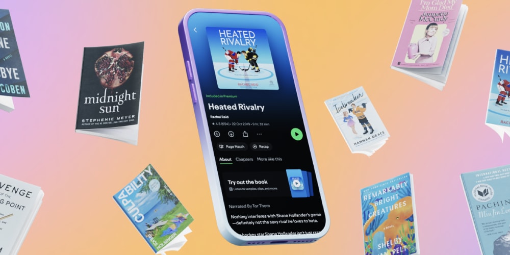 Smartphone affichant un livre audio 'Heated Rivalry', entouré de livres de poche.