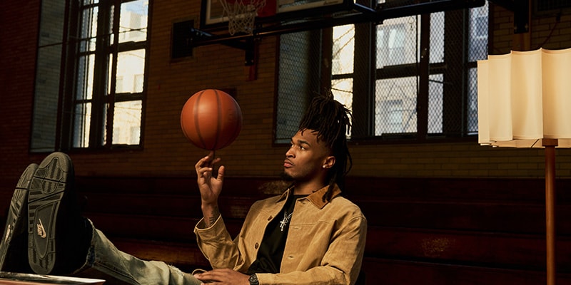 Homme jonglant avec un ballon de basket dans un gymnase.