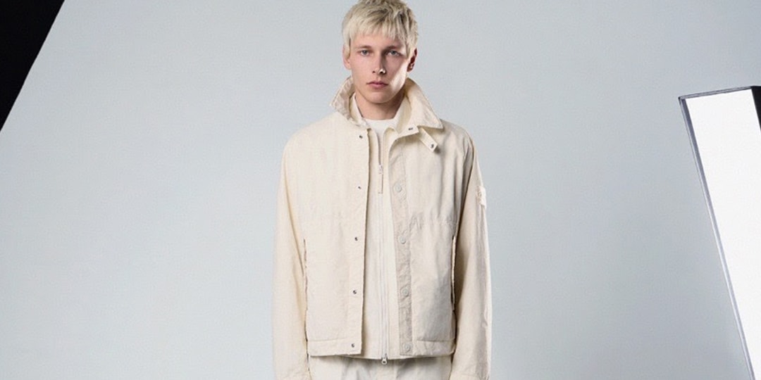 Homme en veste beige sur fond clair, ambiance studio.