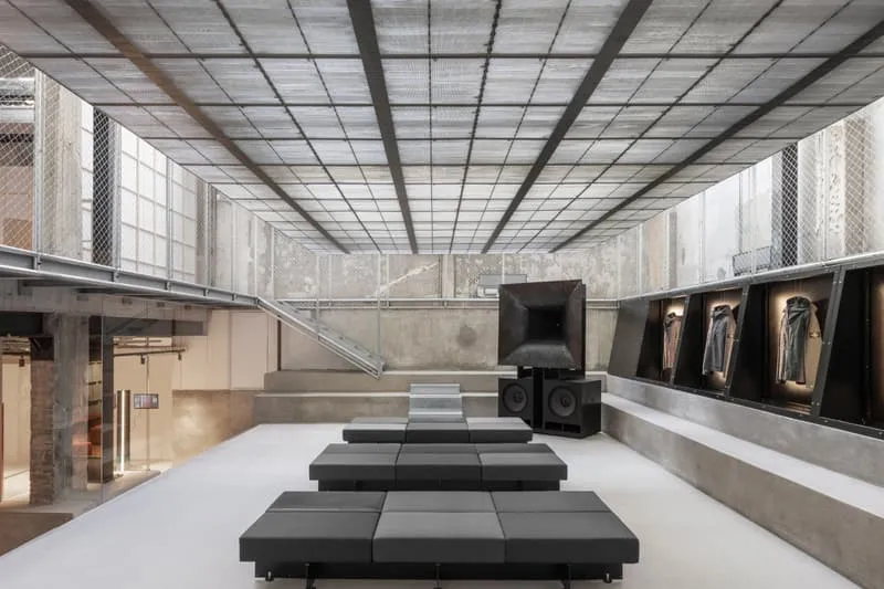 Intérieur moderne avec plafond grillagé et sièges noirs, style industriel.