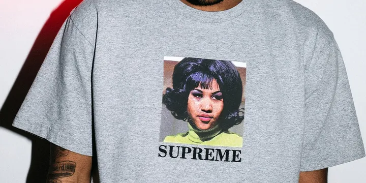 T-shirt gris avec une image et 'SUPREME' imprimé.