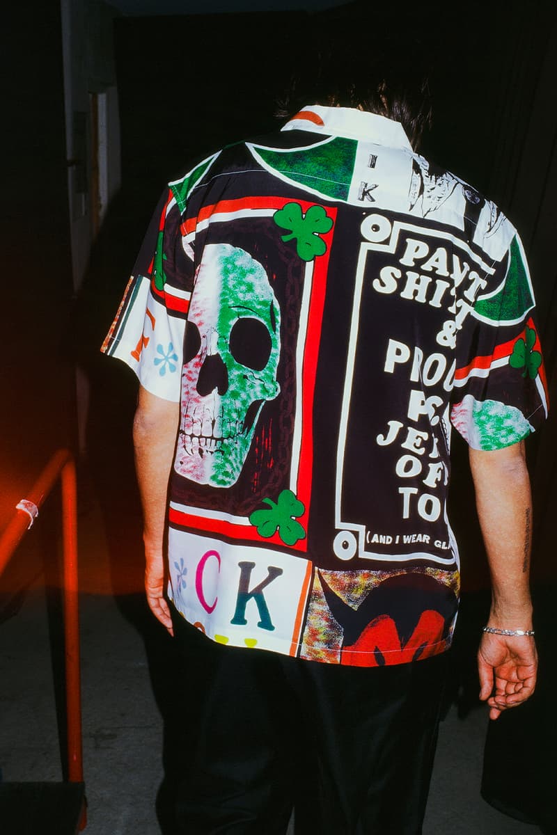 Homme portant une chemise colorée avec des motifs graphiques et un crâne.