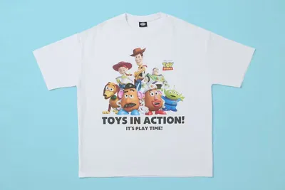 T-shirt blanc avec personnages de Toy Story et texte 'Toys in Action.'