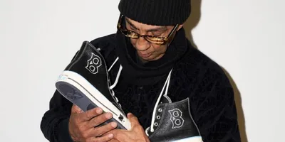 Une personne regarde des chaussures noires avec attention.