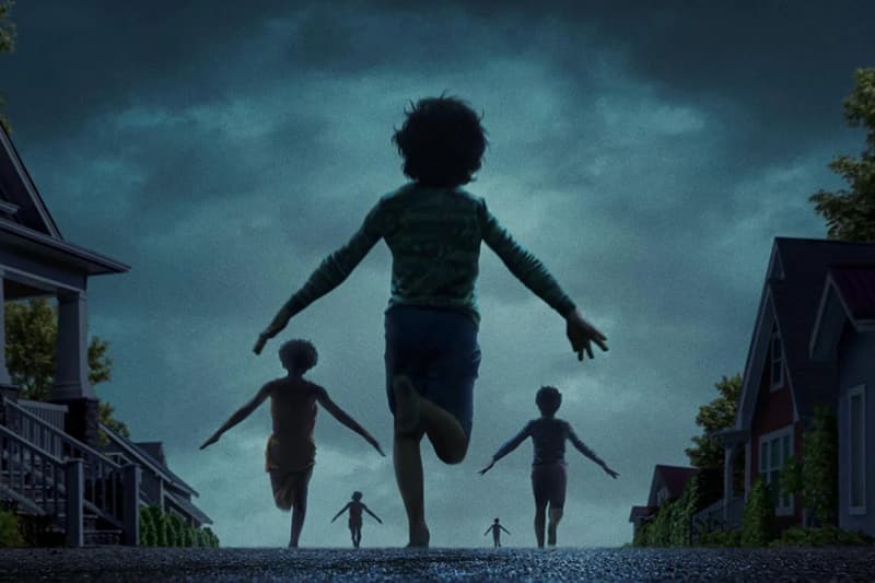 Des enfants courent dans une rue sombre vers la lumière.