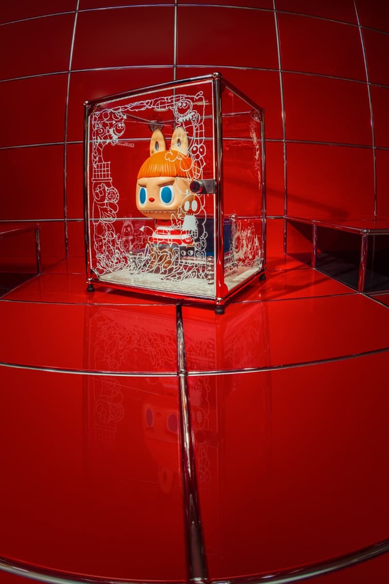 Figurine en cube transparent sur fond rouge vibrant.