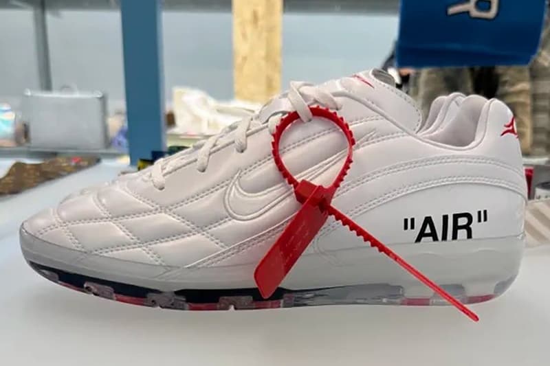Chaussure blanche avec l'inscription 'AIR' et un attache rouge.