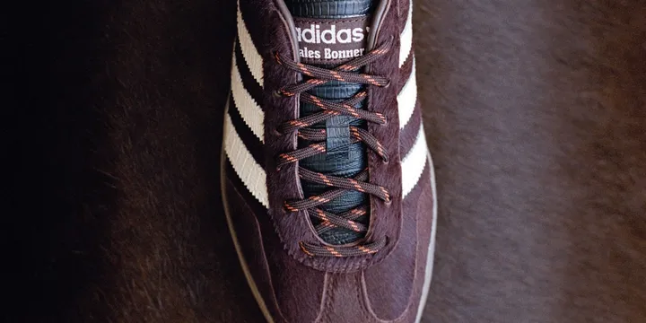 Chaussure Adidas marron avec rayures blanches et lacets marron.