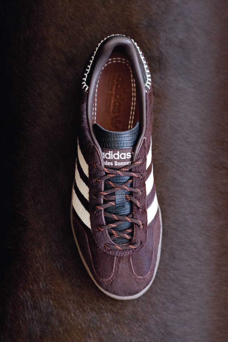 Chaussure marron Adidas avec rayures blanches sur fond marron.