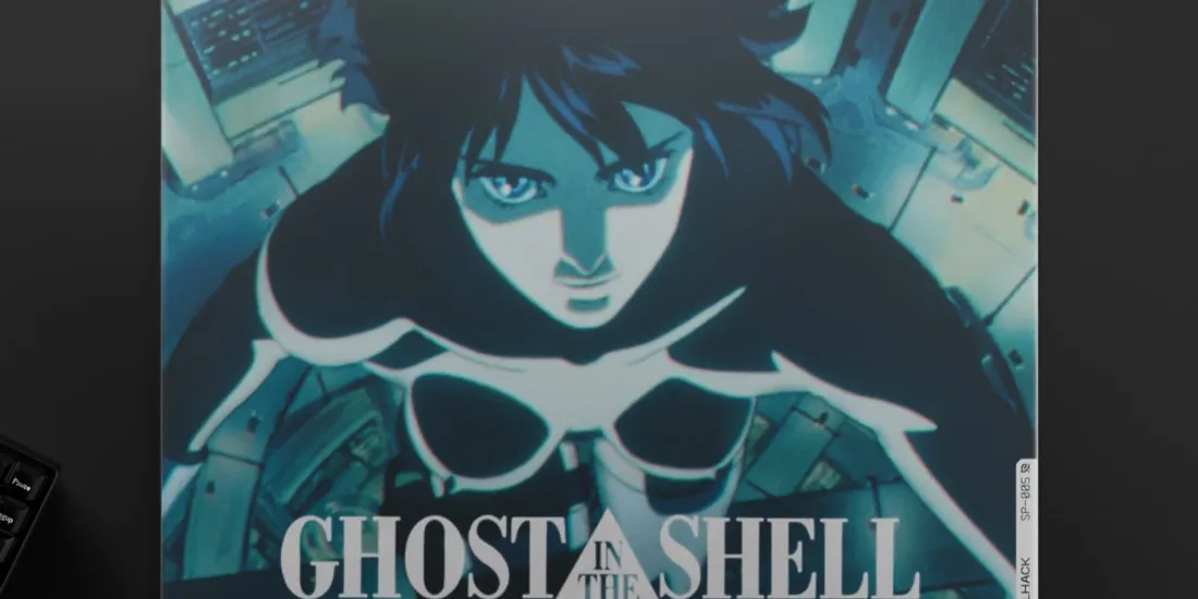 Femme en combinaison future sur fond techno, 'GHOST IN THE SHELL' écrit en bas.