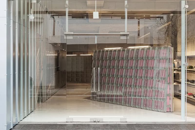 Intérieur moderne avec mur de livres incliné et surface en verre.