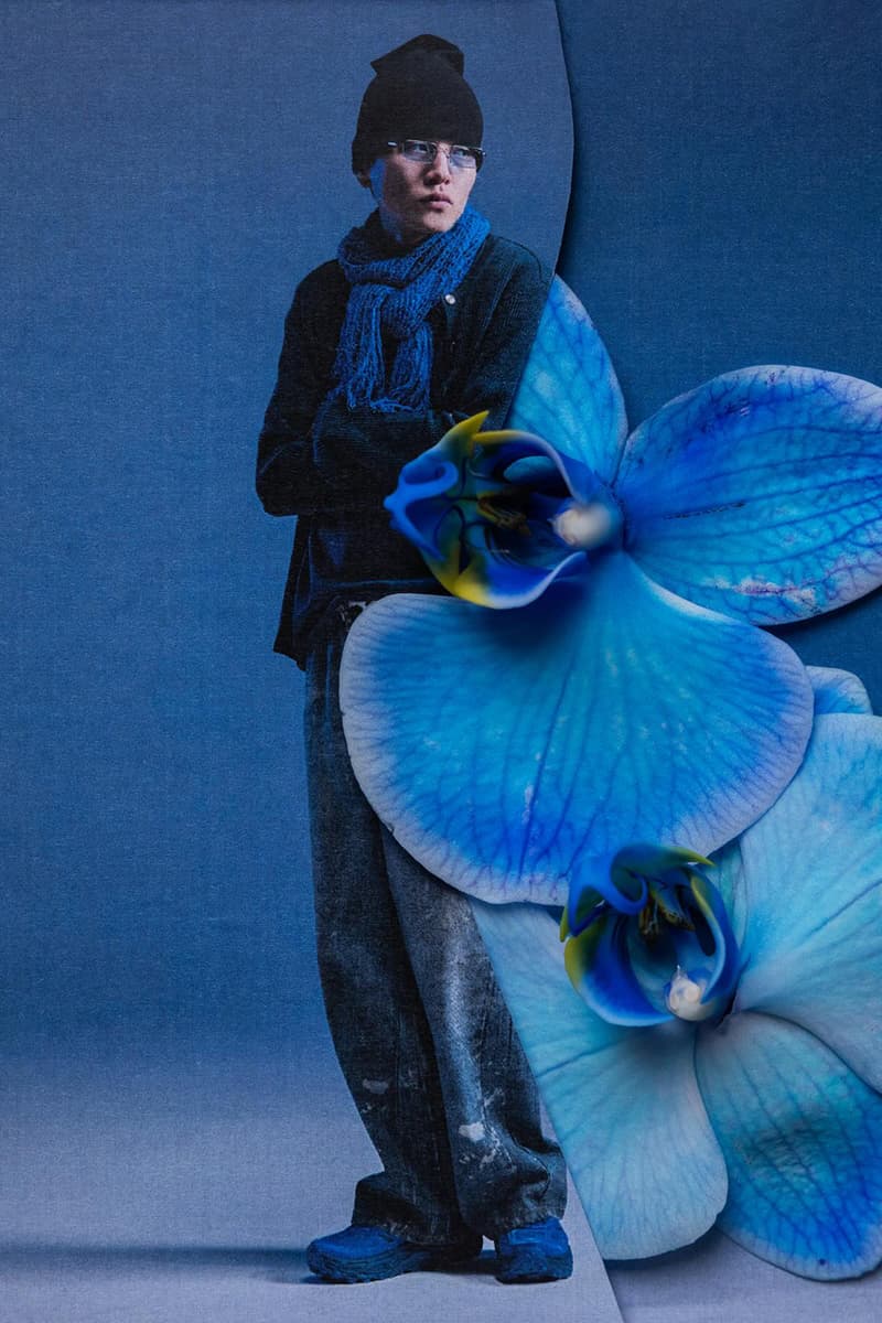 Homme en vêtements bleus avec fleurs bleues sur un fond également bleu.