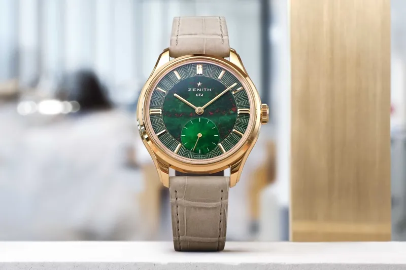 Montre en or avec cadran vert, bracelet beige.