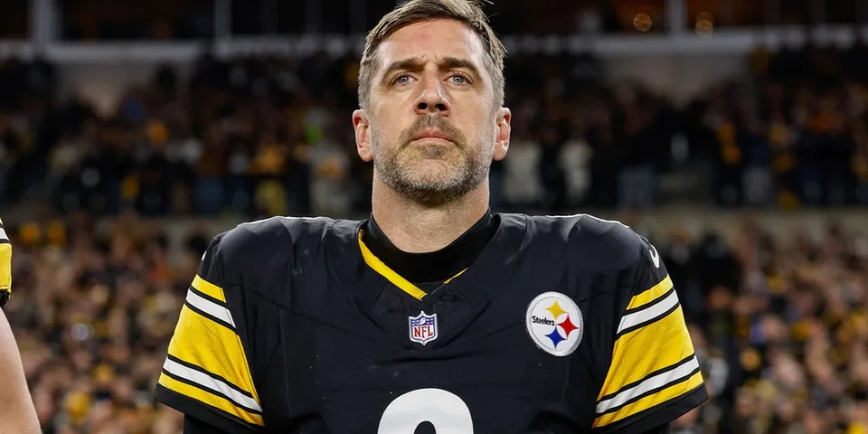 Joueur de football américain en uniforme, regard sérieux vers le haut.
