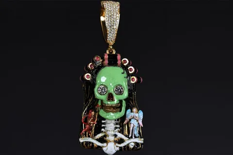 Pendentif crâne vert avec détails complexes et décorations colorées.